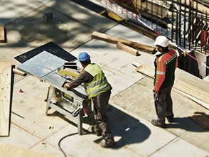 picture of two men on a construction site, with one giving direction to the other